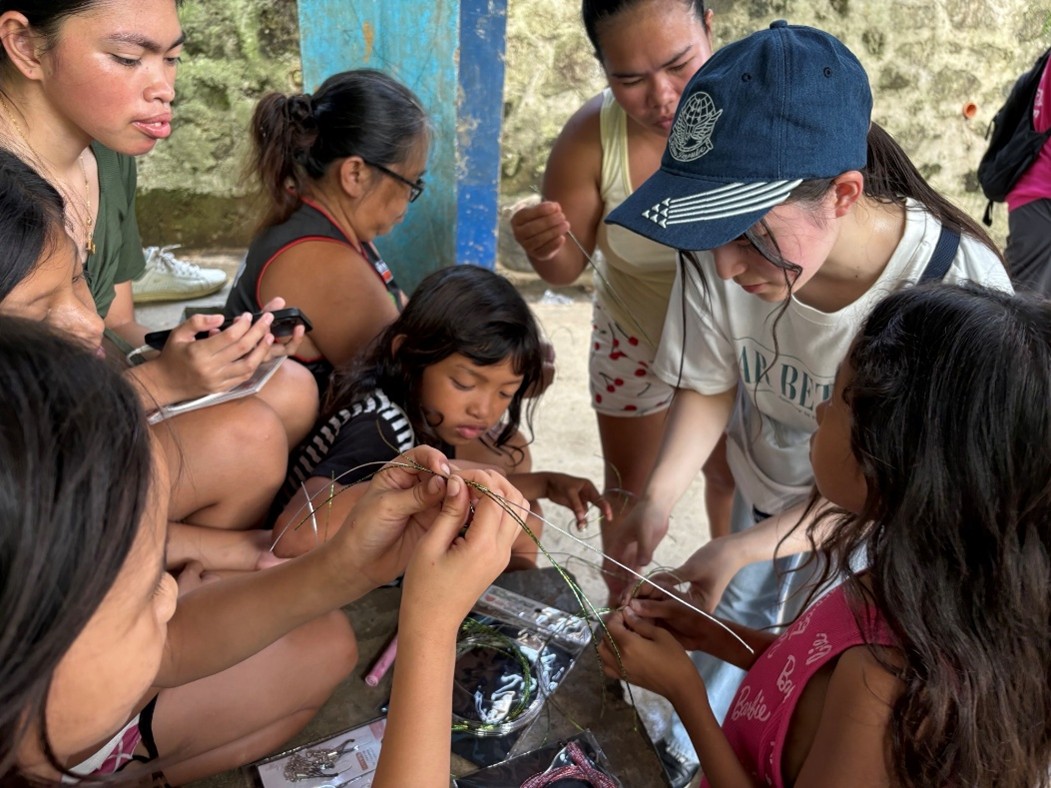 山村集落にて子どもたちに水引の作り方を紹介する様子