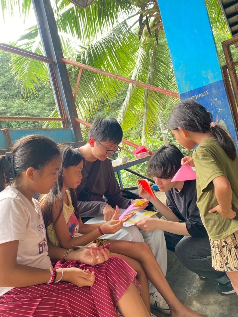 山村集落にて子どもたちに折り紙を紹介する様子